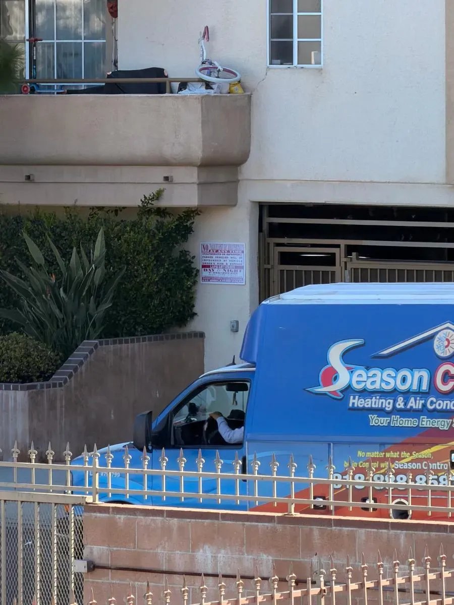 Season Control service van parked at a multi-unit building for an HVAC service call